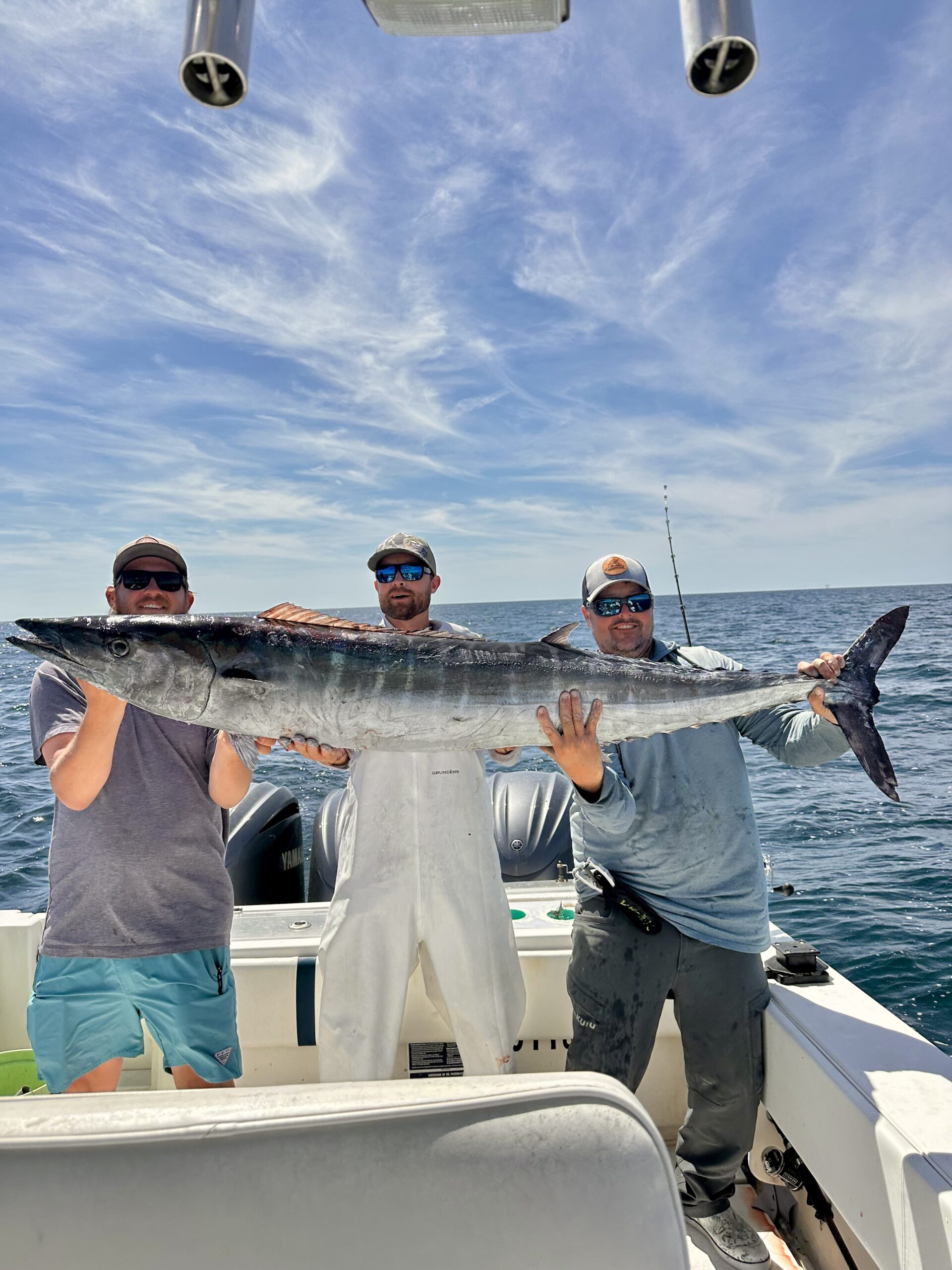 Three anglers with a wahoo catch aboard the Ring Money